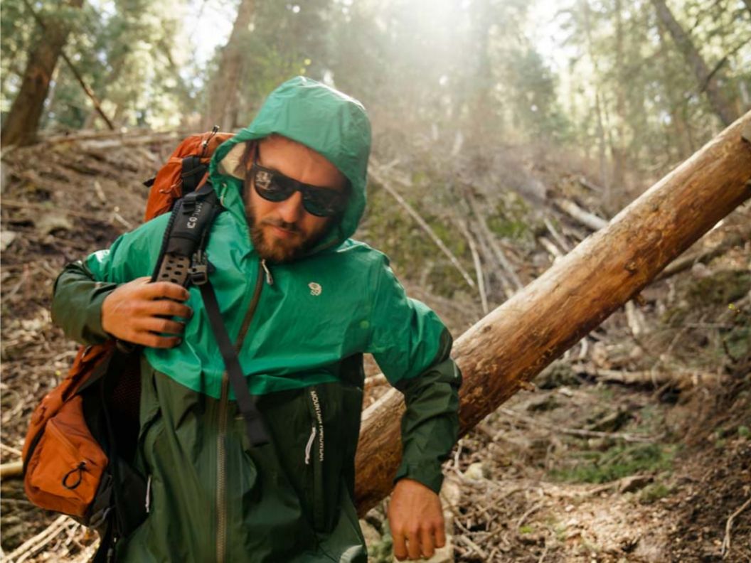 A man putting on a backpacking hiking in a forest